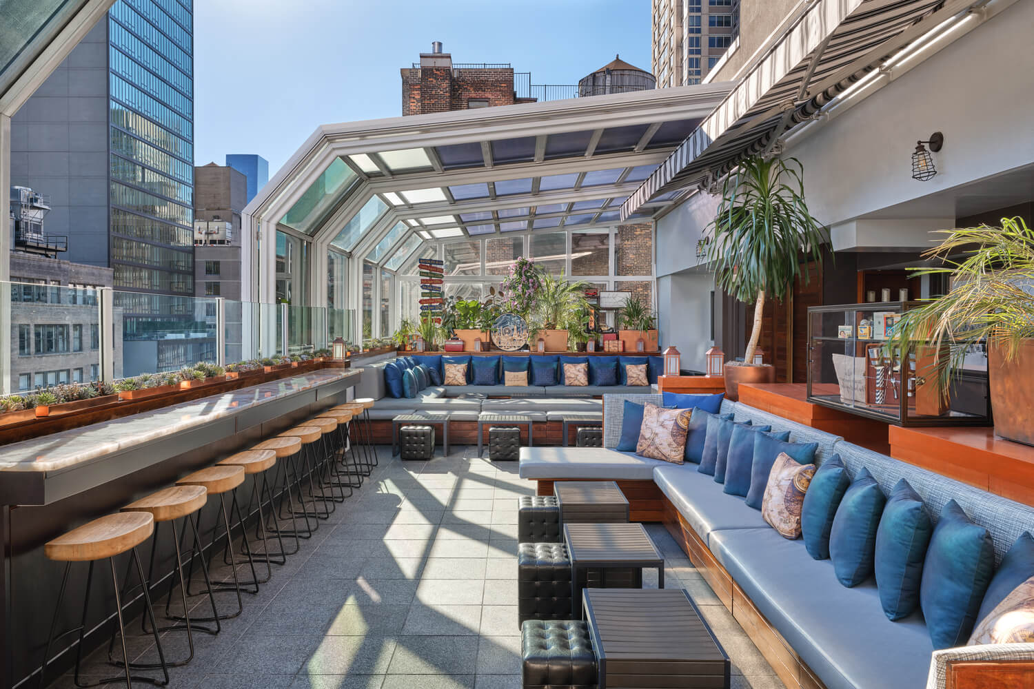 Rooftop bar with garden setting and afternoon views of New York city skyline