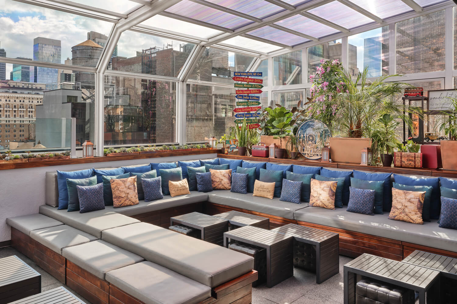 Rooftop bar with garden setting and afternoon views of New York city skyline